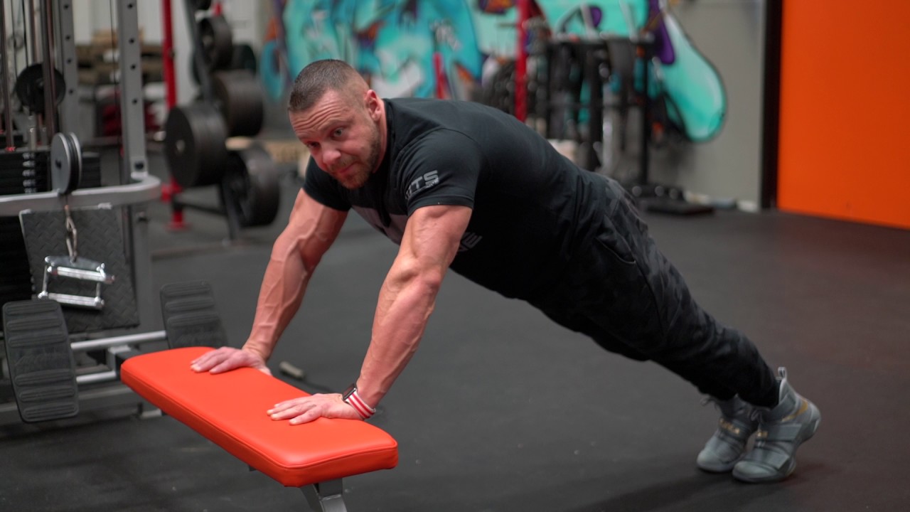 A close-up of hands placed on the edge of a sturdy counter for an incline pushup, showing wrist-neutral position and a straight line from shoulders to hips