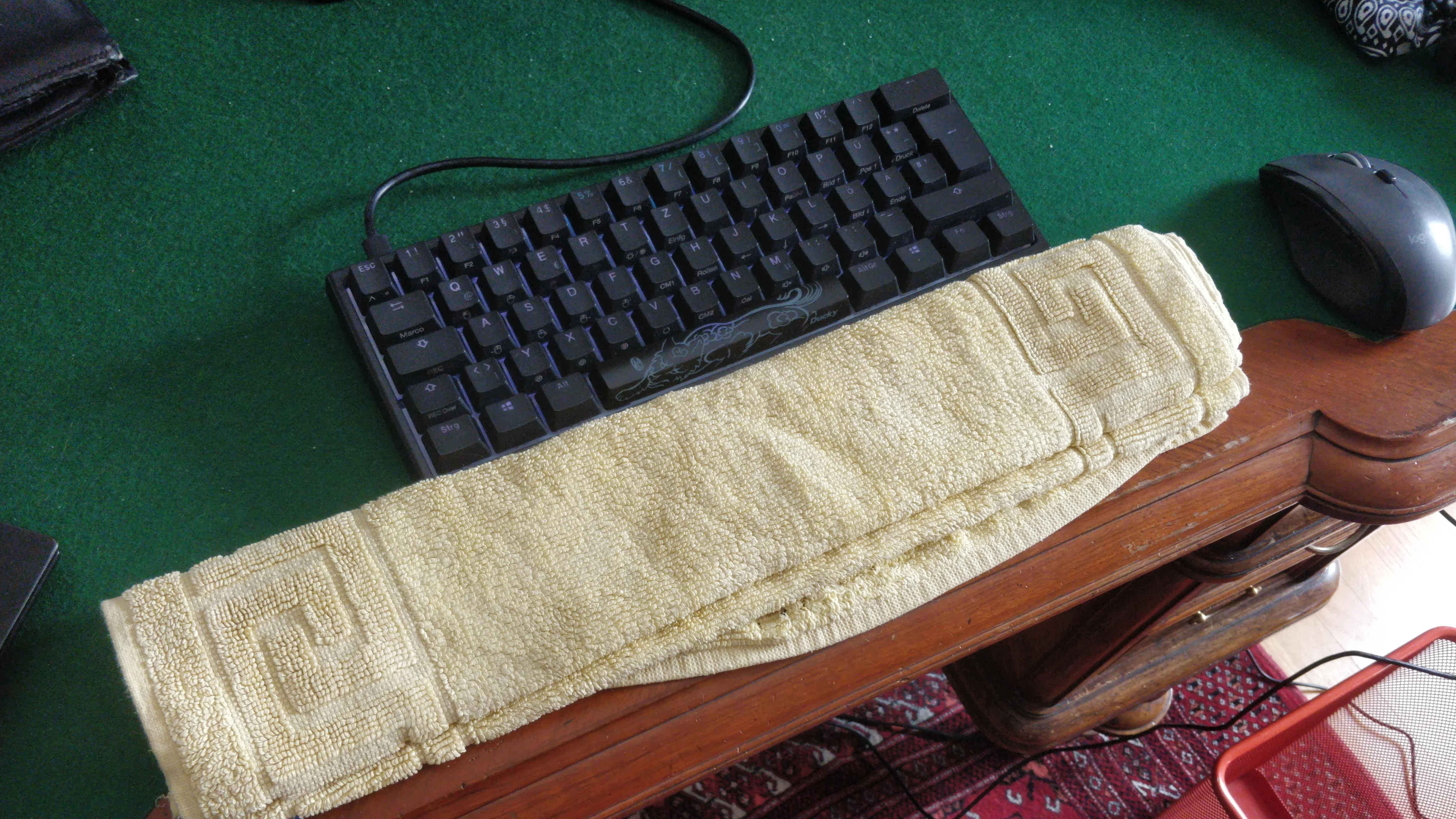 A folded towel placed on an exercise mat where hands would land, demonstrating a simple wrist-support setup for floor exercises