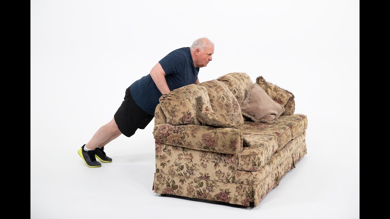 A person doing incline push-ups with hands on a sturdy couch, maintaining a straight body line