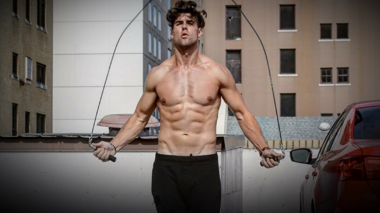 A person doing quick, low jumps with a jump rope in a garage, elbows close to the ribs