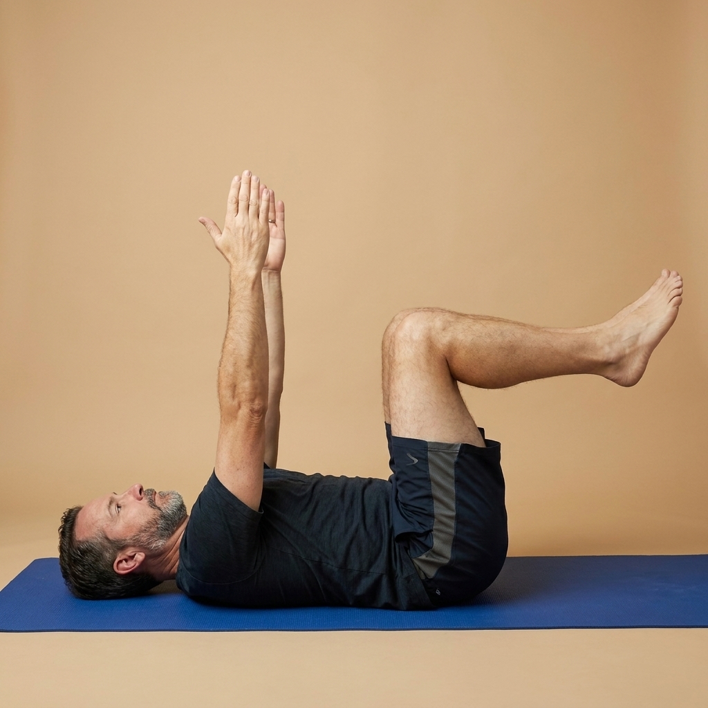 A person on a mat performing a dead bug, arms reaching toward the ceiling and knees bent at 90 degrees above hips, preparing to extend the opposite arm and leg while keeping the ribs stacked and the low back steady