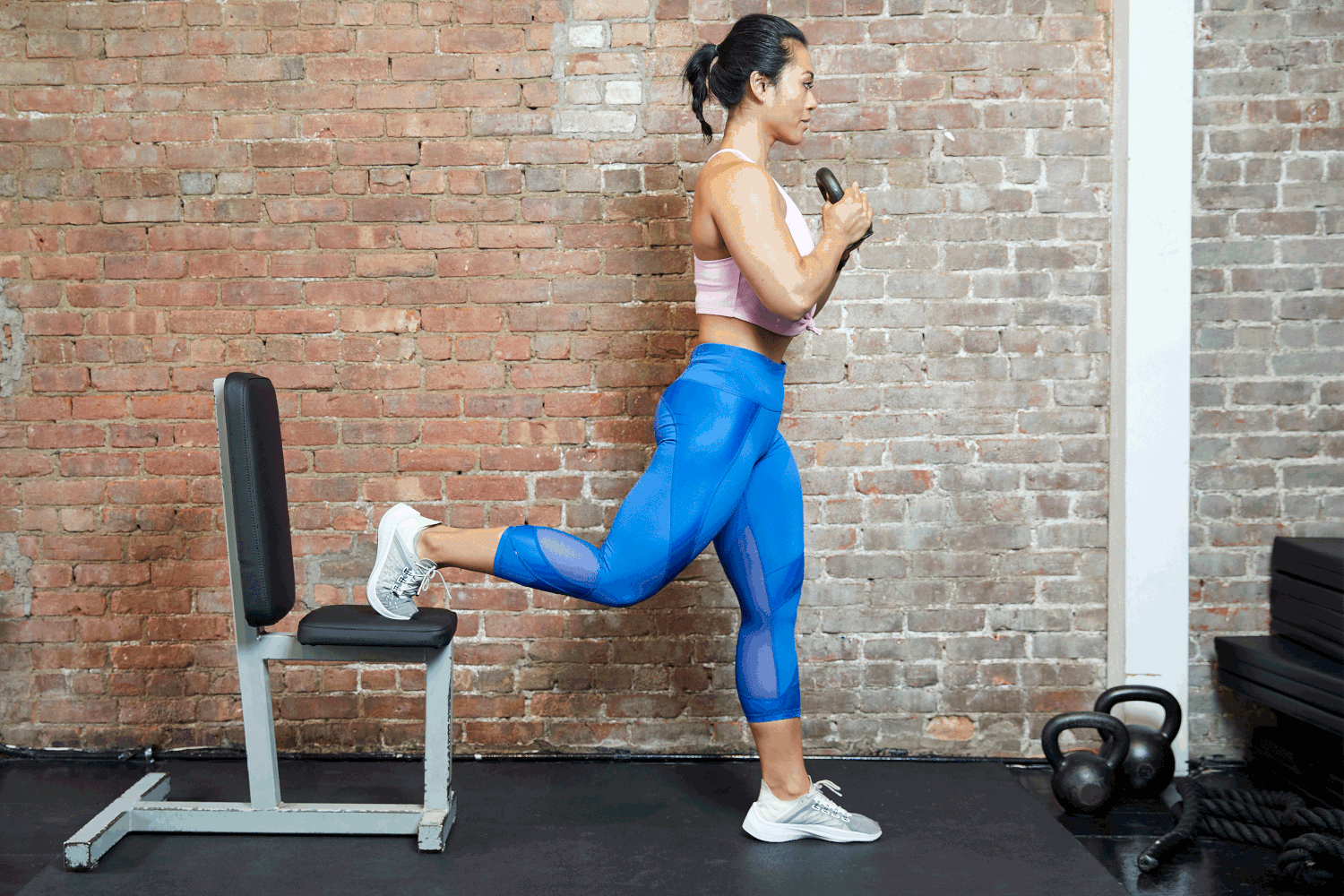 A person performing a split squat at home with an upright torso, front foot flat, and front knee tracking in line with the toes