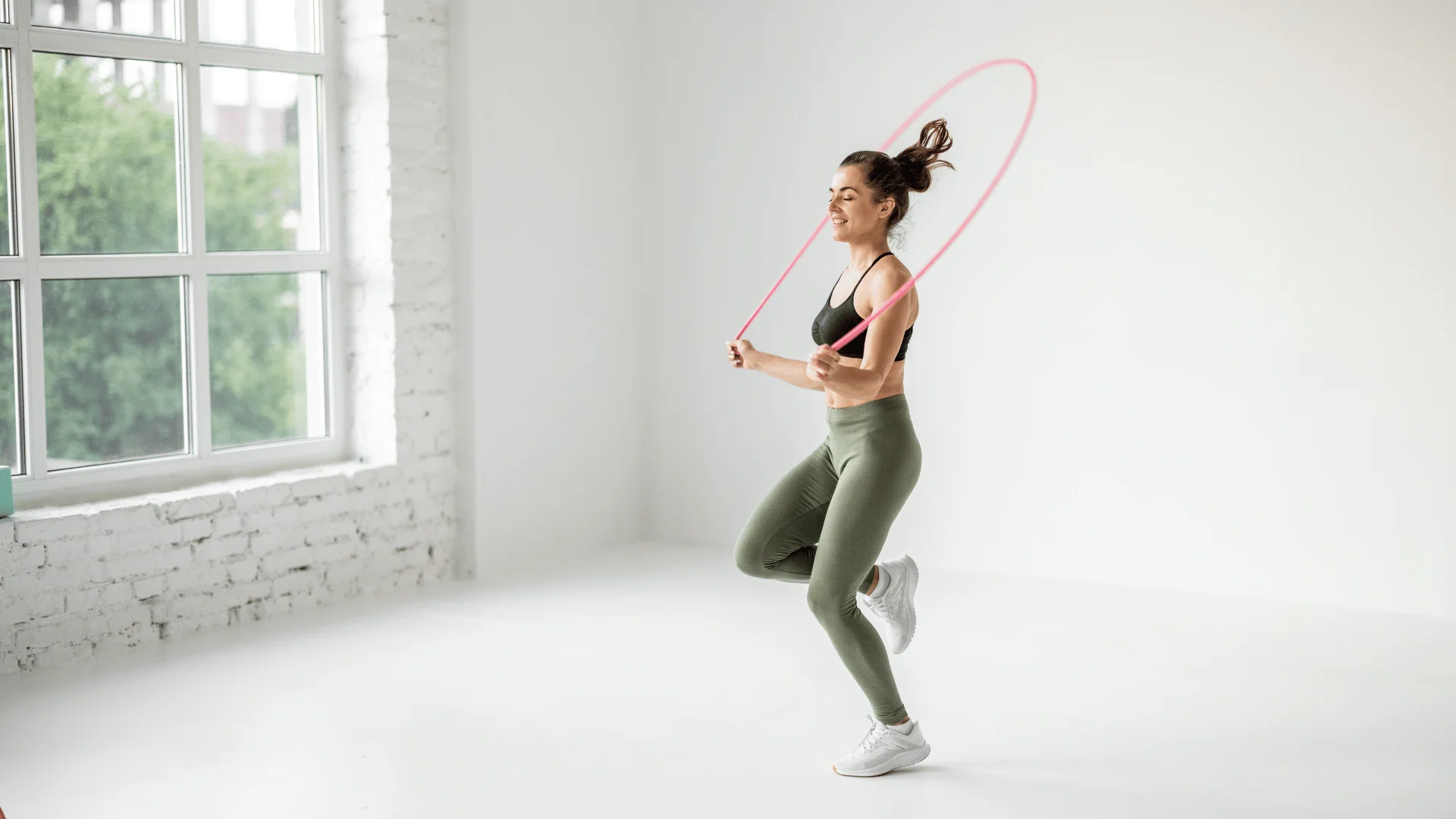 A phone displaying an interval timer on a garage mat next to a jump rope during a home workout