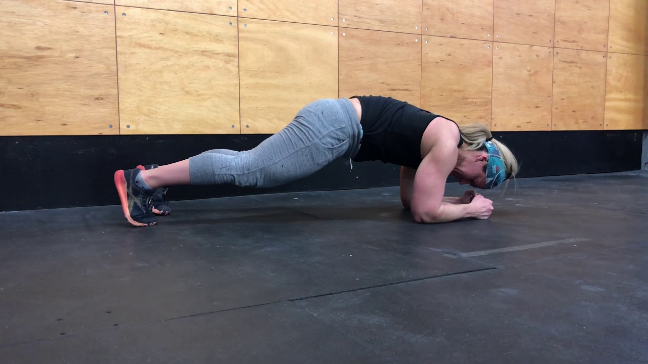 A side view of a forearm plank showing ribs pulled down and pelvis slightly tucked to keep the lower back neutral