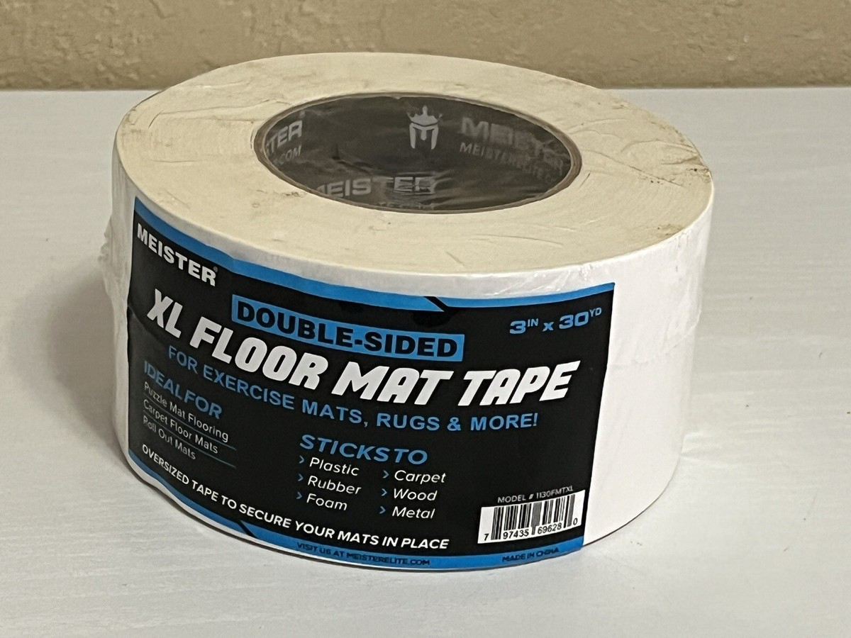 A textured non-slip exercise mat on a hardwood floor, laid flat with the corners smoothed down to reduce slipping