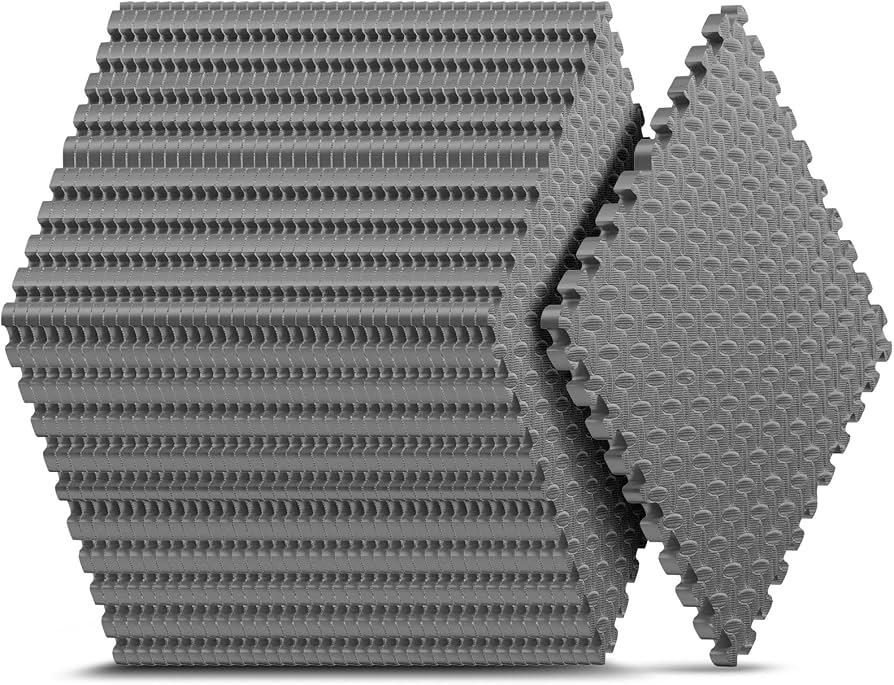Interlocking foam floor tiles placed under an exercise mat to add extra cushioning and reduce vibration on an apartment floor